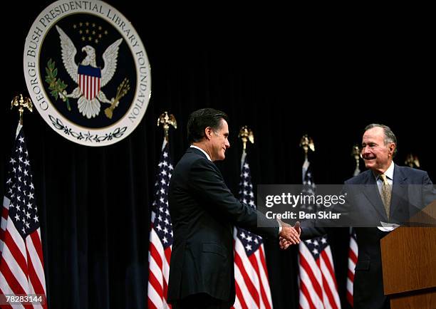 Former Massachusetts Governor and Republican President hopeful Mitt Romney shakes hands with former U.S. President George Bush before speaking on...