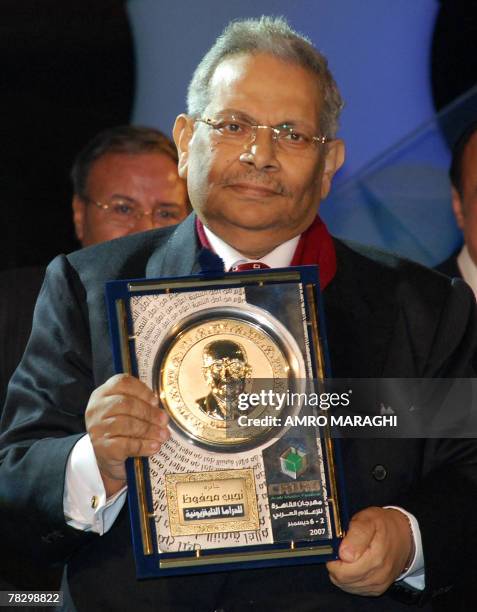 Egyptian scriptwriter Osama Anwar Ukasha holds the Naguib Mahfuz award for screenwriting during the Cairo international film festival in Nasr City in...
