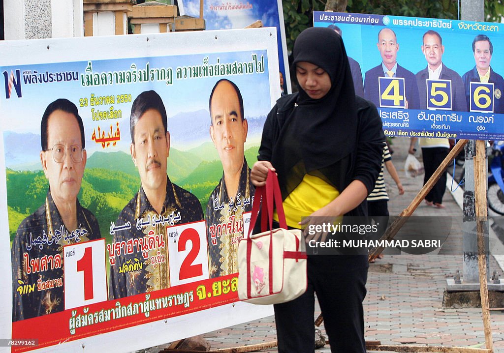 A Thai Muslim woman walks past election