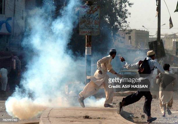 Pakistani protesters of Islami Jamiat Tulba, a student wing of fundamentalist party of Jamaat-i-Islami, flee as police fire teagas to disperse the...