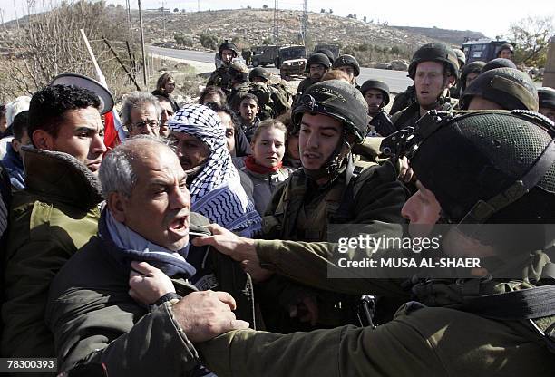 An Israeli soldier grabs APTN cameraman Eyad Hamad as Palestinians and foreign peace activists protest against the construction of the controversial...