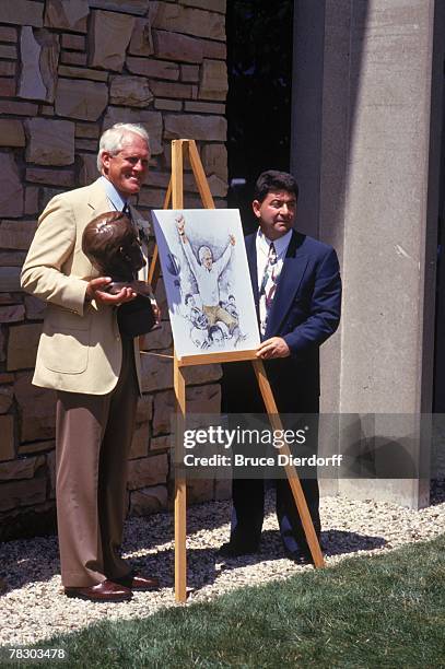 Coach Bill Walsh holds his bust as he stands next to San Francisco 49ers owner Eddie DeBartolo after his induction into the Pro Football Hall of Fame...