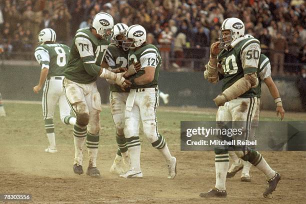 Quarterback Joe Namath of the New York Jets is mobbed by his teammates after throwing a touchdown pass during a 17-14 victory over the Miami Dolphins...