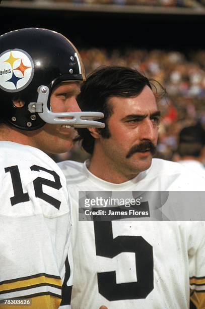 Quarterback Terry Bradshaw of the Pittsburgh Steelers watches from the sideline with backup quarterback Terry Hanratty during an NFL game against the...