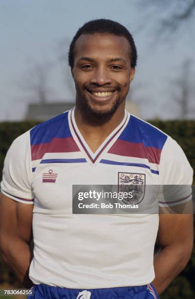 English international professional footballer Cyrille Regis of West Bromwich Albion posed wearing an England national football team shirt, circa 1982.