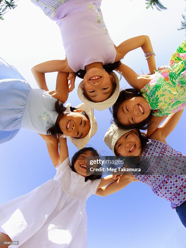 Portrait of five girls standing in a huddle and smiling