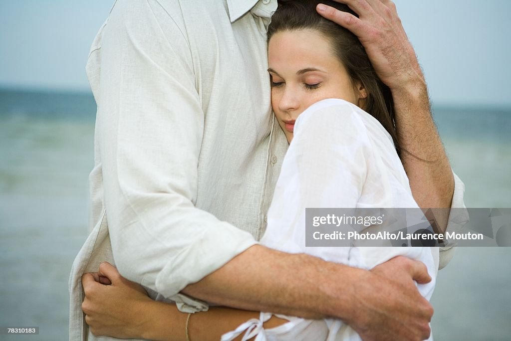 Man and young female companion embracing, close-up