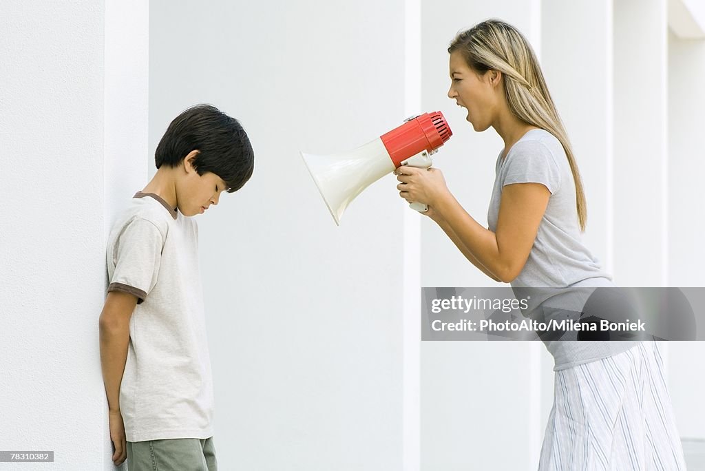 Woman shouting at boy through megaphone