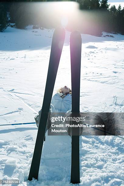 young skier lying on back in snow, view through skis - northern european descent ストックフォトと画像