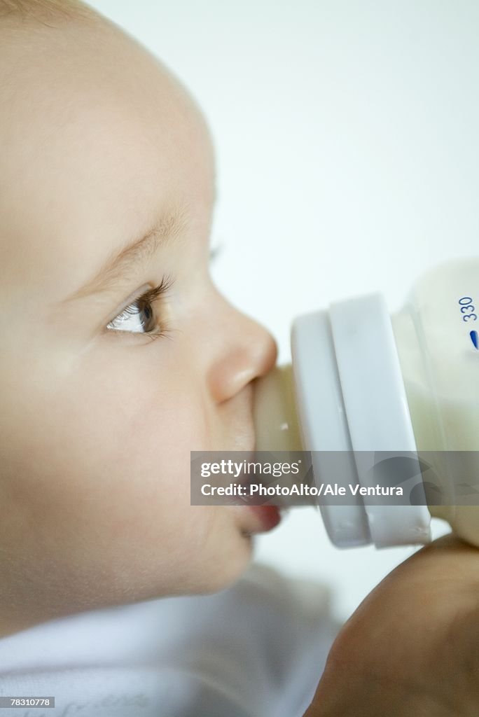 Baby drinking from bottle, extreme close-up, side view