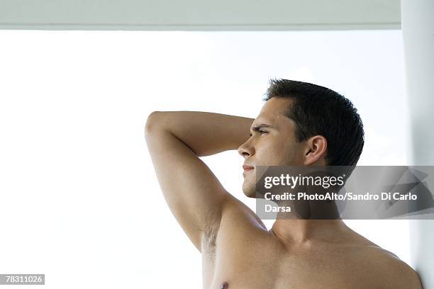 young man standing with one arm raised, profile - semi dress stock pictures, royalty-free photos & images