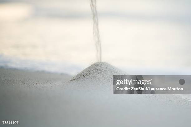 sand falling onto pile on beach - sand pile stock pictures, royalty-free photos & images