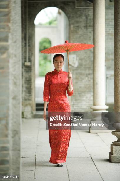 young woman wearing traditional chinese clothing, walking with parasol - the cheongsam stock pictures, royalty-free photos & images