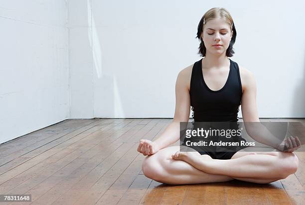 woman meditating - halber lotussitz stock-fotos und bilder