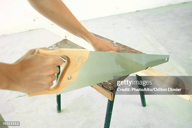 woman sawing piece of wood, close-up of hands - hand saw stock pictures, royalty-free photos & images