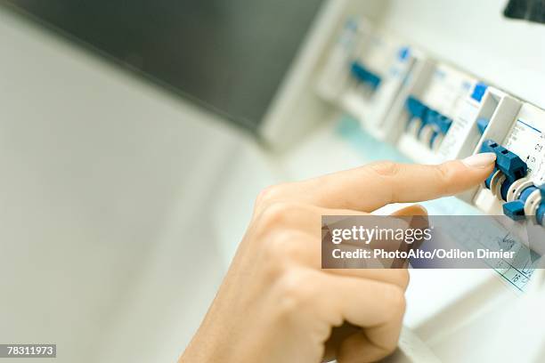 woman switching fuse in fuse box, close-up of hand - fuse box stock pictures, royalty-free photos & images
