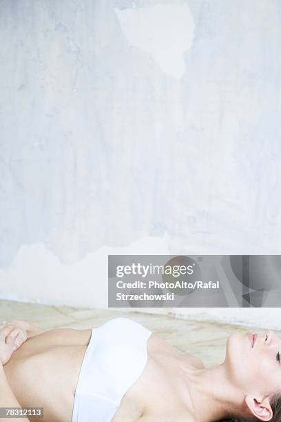 young woman lying on back, eyes closed, dressed in tubetop - strapless stock-fotos und bilder