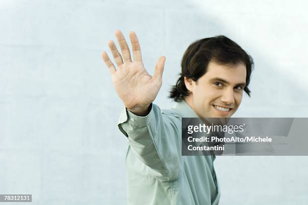 man waving at camera, smiling, portrait - waving goodbye stock pictures, royalty-free photos & images