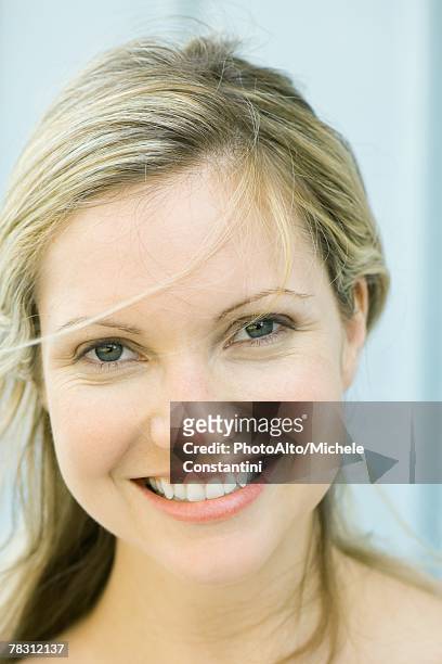 young woman smiling at camera, tousled hair, portrait - frau haarsträhne blond beauty stock-fotos und bilder