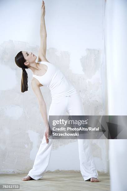 woman standing, doing yoga pose, full length - man standing full length side stock-fotos und bilder