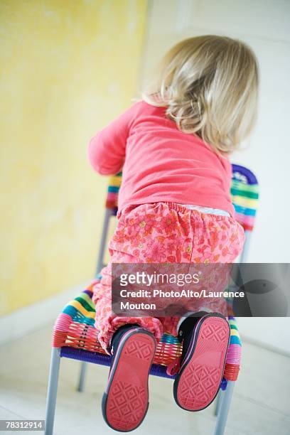 blonde toddler girl climbing on chair, rear view - girl soles stock pictures, royalty-free photos & images