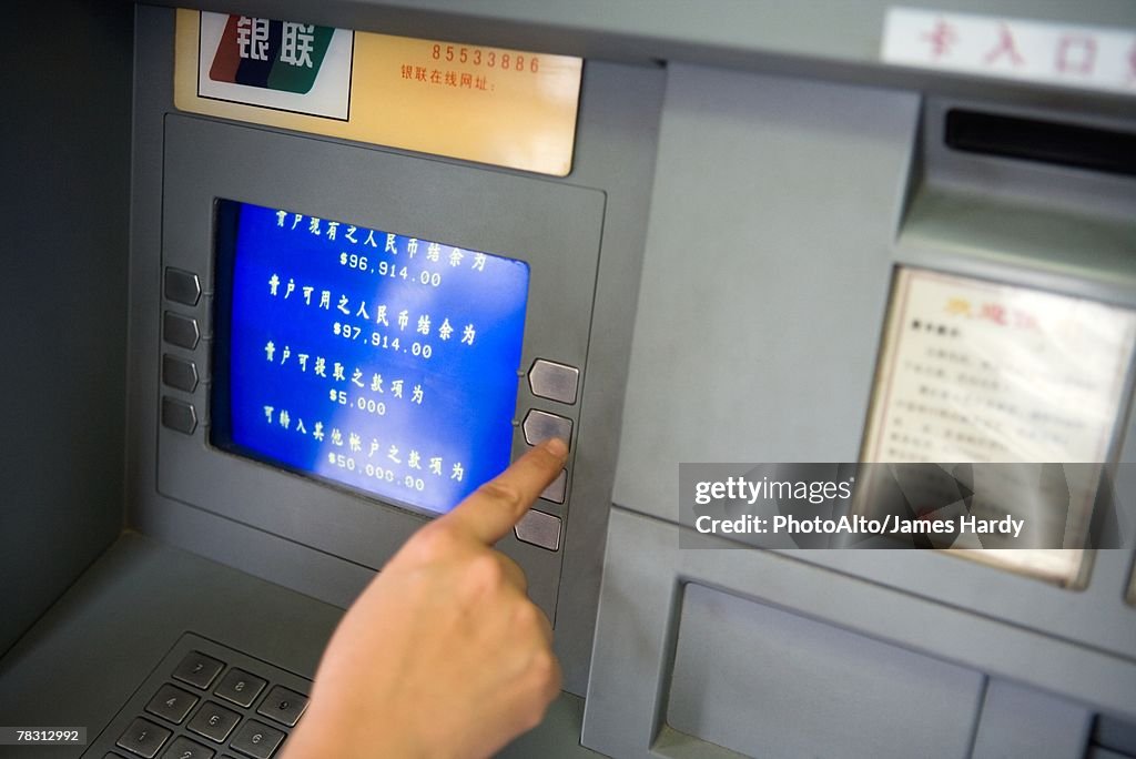 Person using ATM in China, cropped view