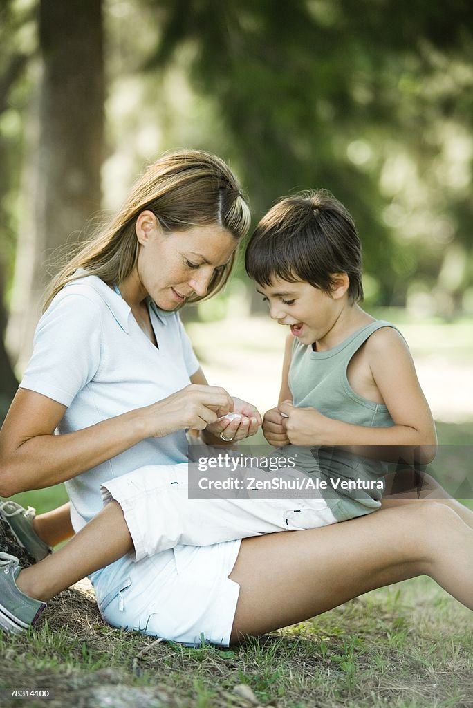 Mother And Son Sitting Outdoors Playing Together HighRes Stock Photo