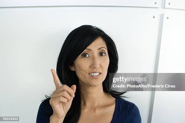 woman holding up finger, looking at camera - shaking finger stock pictures, royalty-free photos & images