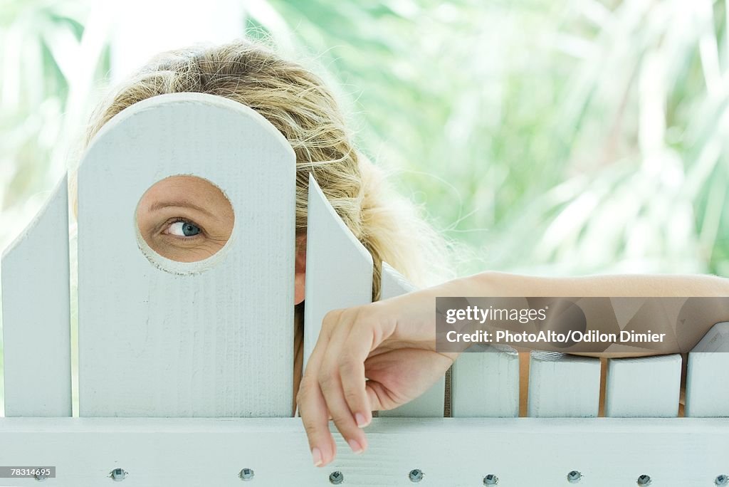 Woman looking through hole 