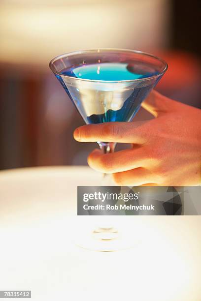 hand with martini - blue martini glasses stock-fotos und bilder