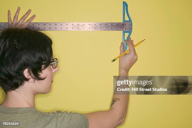woman measuring wall - meter stick stock pictures, royalty-free photos & images