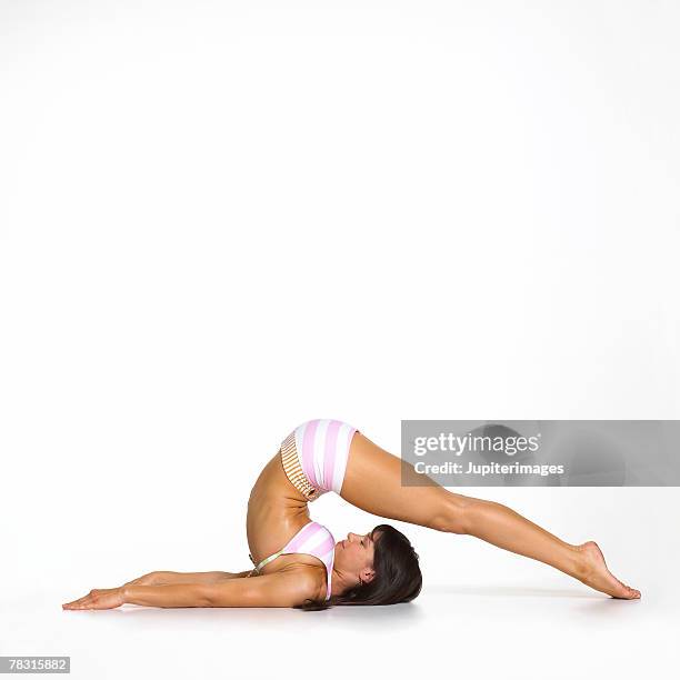 woman in yoga plough pose - boyshorts stockfoto's en -beelden