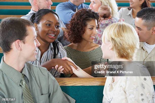 congregation greeting each other in church - congregation stock-fotos und bilder