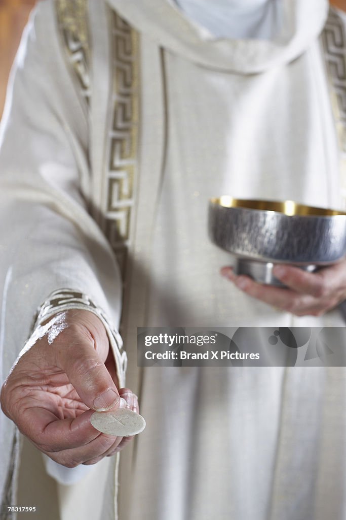 Priest with Communion wafer and chalice