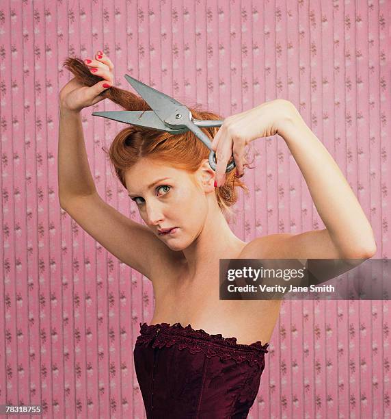 woman cutting hair with oversize scissors - gefärbtes haar stock-fotos und bilder