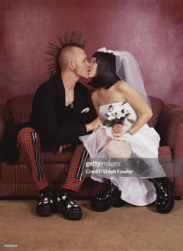 Punk bride and groom kissing