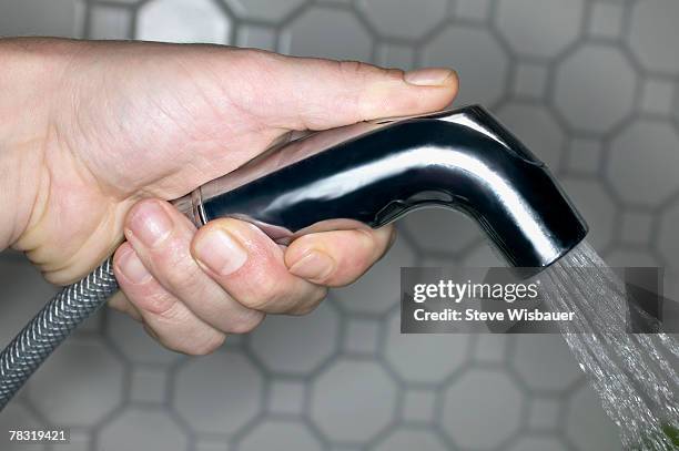 person holding nozzle and spraying water - close up of a cleansing spray nozzle stock pictures, royalty-free photos & images