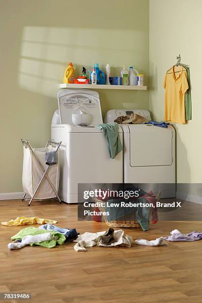 laundry room with clothes on floor - abstellraum stock-fotos und bilder