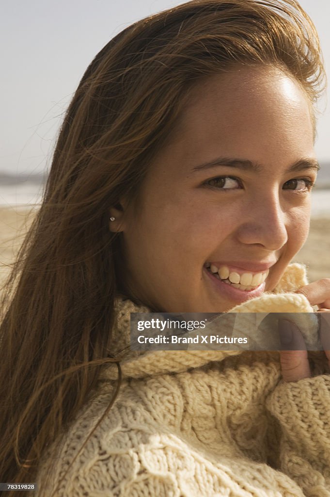 Portrait of girl wearing sweater on beach