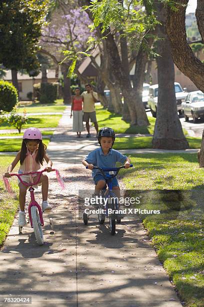 kids riding bikes - training wheels stock pictures, royalty-free photos & images