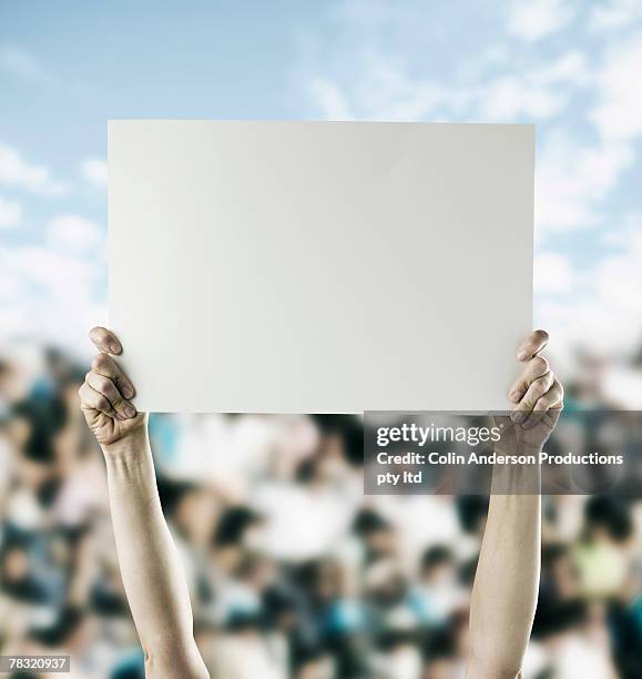 person in crowd holding blank sign - stadion tafel stock-fotos und bilder