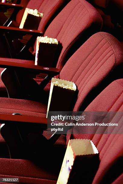 popcorn bags in movie theater seats - kinosaal stock-fotos und bilder