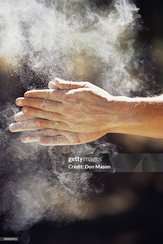 Rock Climber rubbing dust on hands