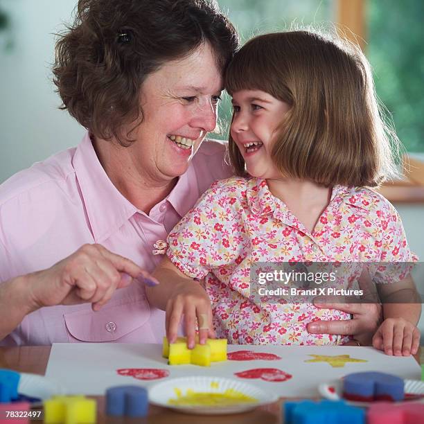 grandmother and granddaughter painting - 4 girls finger painting stock pictures, royalty-free photos & images