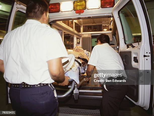 emts loading patient into ambulance - operating gown stock pictures, royalty-free photos & images