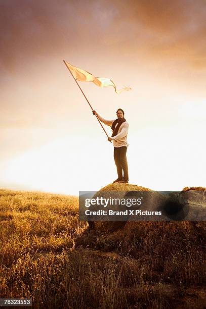 man holding flag in field - white flag stock pictures, royalty-free photos & images