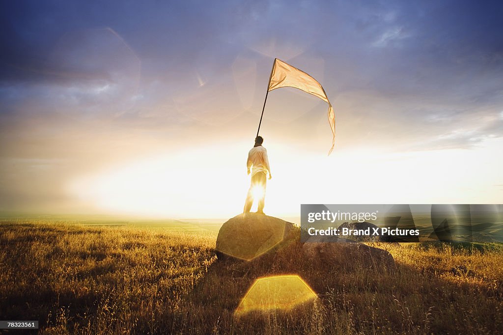 Person standing in field with flag