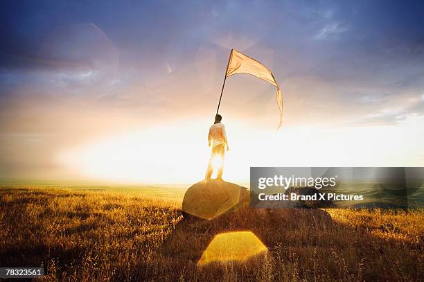 person standing in field with flag - white flag stock-fotos und bilder