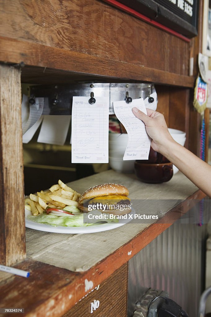 Waitress ordering food from diner kitchen