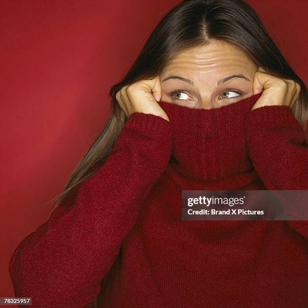 playful woman peeking out of turtleneck - col roulé photos et images de collection